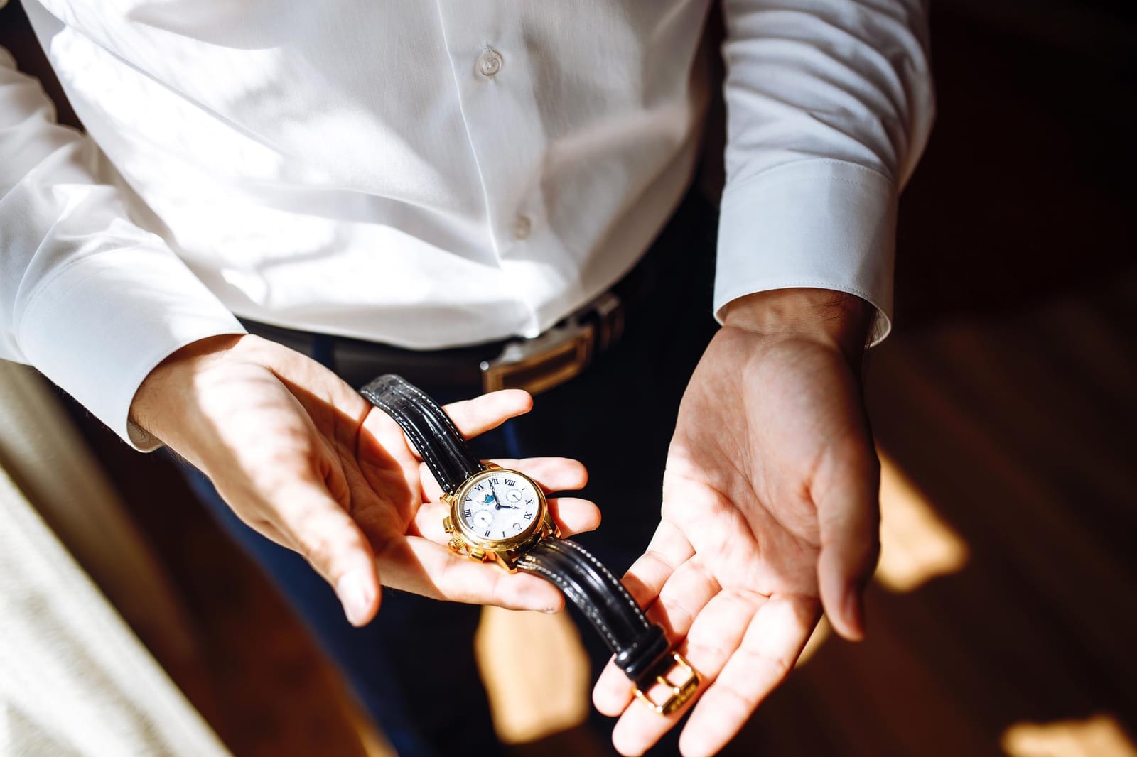 Uomo elegante controlla l'ora sul proprio orologio da polso